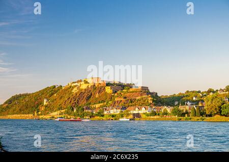 Ehrenbreitstein Fortezza edificio medievale sulla collina di est ripida riva del fiume Reno, vista dalla città di Coblenza, cielo blu sfondo, Renania-Palatinato stato, Germania Foto Stock