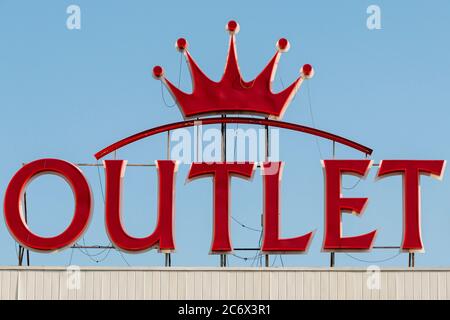 Scritta e logo al neon LED Royal Crown rosso sul tetto dell'edificio dell'outlet Foto Stock