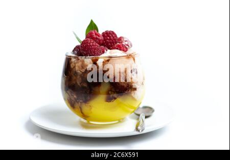 Parfait di frutta al lampone in una tazza di vetro isolata su bianco Foto Stock