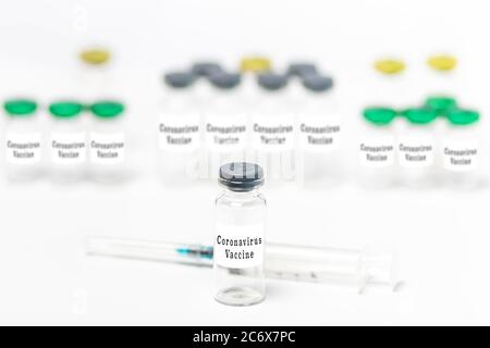 Campione di siringa ipodermica e flaconcini medici per il vaccino del Coronavirus isolati su fondo bianco. Modello Foto Stock