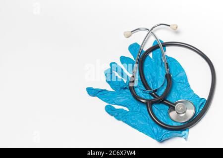 Coppia di guanti medici blu e stetoscopio isolati su sfondo bianco. Primo piano, vista dall'alto Foto Stock