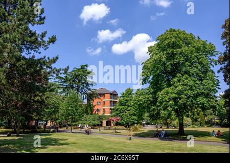 Bromley (Greater London), Kent, Regno Unito. Queens Gardens vicino al centro commerciale Glades a Bromley. Le persone sono sedute nel parco godendo del sole. Foto Stock