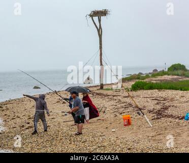 Persone che pescano sotto la pioggia su Shelter Island, NY Foto Stock