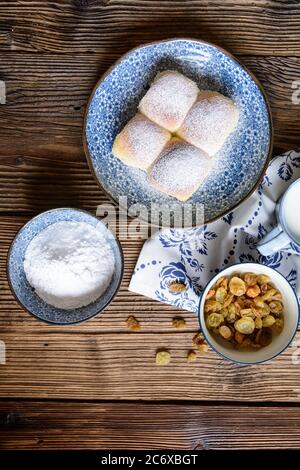 Tradizionali ciambelle di lievito dolce farcite con cagliata, uvetta e cosparse di zucchero in polvere Foto Stock