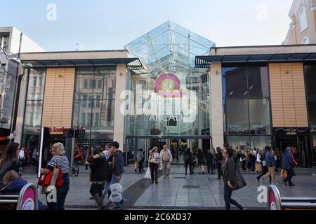 Gli amanti dello shopping su Queen st, fuori dal Queens Arcade a Cardiff, Galles, strada pedonale del Regno Unito Foto Stock