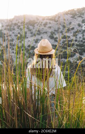 Ragazza in viaggio con un cappello in natura. Concetto di libertà e di uscire in natura. Foto Stock