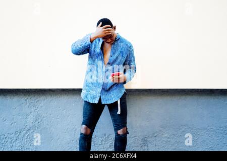 giovane africano che gioca sul suo smartphone Foto Stock