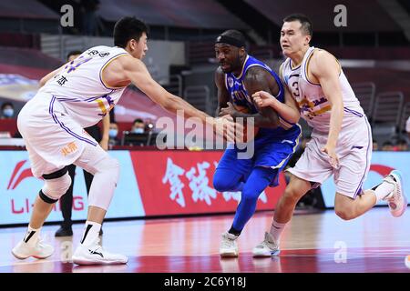 Il giocatore professionista americano di basket Tywon Ronell Lawson di Fujian SBS Xunxing Sturgeons, al centro, protegge la palla durante una partita al primo stadio Foto Stock