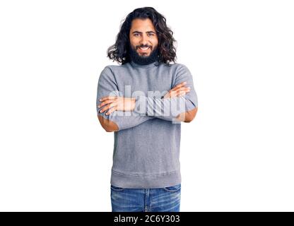 Giovane arabo che indossa abiti casual volto felice sorridente con le braccia incrociate guardando la macchina fotografica. Persona positiva. Foto Stock