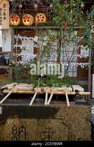 KYOTO, GIAPPONE - 22 OTTOBRE 2007: Il bacino di abluzione dell'acqua (tsukubai) con i tuffatori in legno per la purificazione cerimoniale all'ingresso di Nishiki-T. Foto Stock