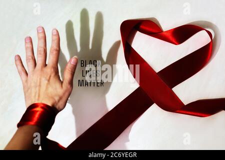 Ombra nera e palma bianca e iscrizione Black Lives Matter. Cuore dal nastro rosso. Simbolo uguale. Nessun concetto di razzismo. Foto Stock