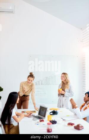 Tempo di brainstorming di multi-etnico team aziendale che lavorano in ufficio, discutere nuove idee in ufficio riunioni, utilizzando il laptop Foto Stock