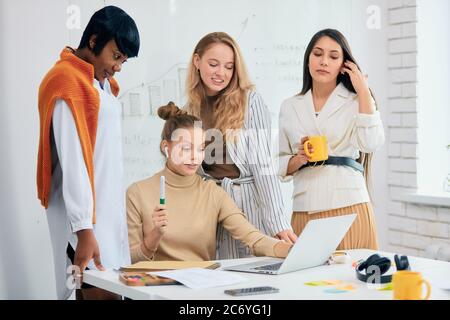 Donne diverse di successo si sono riunite per discutere di nuovo progetto di business, idee e condividere esperienze tra loro. Giovani Signore che indossano abiti casual wor Foto Stock
