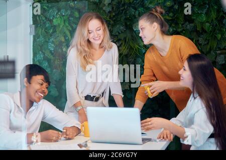 Lavoro di squadra di donne caucasiche e africane in affari in casi, discutendo idea o progetto di affari, concetto di avvio di affari Foto Stock