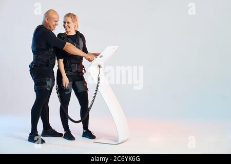 Felice coppia attraente divertirsi con le attrezzature EMS. Foto a lunghezza intera. Felicità, tempo libero, tempo libero. Spazio copia Foto Stock