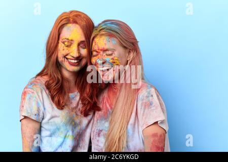 due ragazze ridenti che prendono parte al colorfest, le donne si liberano della fatica, delle emozioni negative, delle tradizioni culturali. Foto Stock