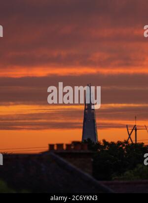 Wimbledon, Londra, Regno Unito. 13 luglio 2020. La giornata inizia a Londra con un bellissimo cielo all'alba. Lo Shard, nel centro di Londra, a 13 miglia di distanza, si infranse nel caldo atmosferico sopra i tetti dei sobborghi sud-ovest. Credit: Malcolm Park/Alamy Live News. Foto Stock