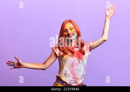 donna molto gioiosa che alza le braccia, esprime felicità, umore positivo. sfondo viola isolato, studio shot. Foto Stock