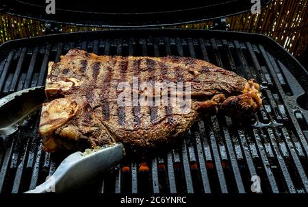Cottura della bistecca di ossa sulla griglia per barbecue Foto Stock