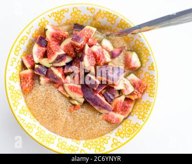 Porridge di amaranto per la prima colazione con i fichi in una ciotola gialla vista superiore Foto Stock