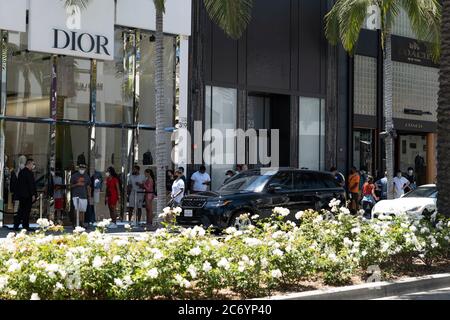 Beverly Hills, CA/USA - 12 luglio 2020: Linea di clienti socialmente distanzianti in maschere facciali aspettano fuori dal negozio Dior Rodeo Drive Foto Stock