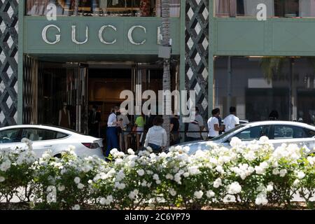 Beverly Hills, CA/USA - 12 luglio 2020: La linea di clienti socialmente distanzianti in maschere facciali attende fuori dal negozio Gucci su Rodeo Drive Foto Stock