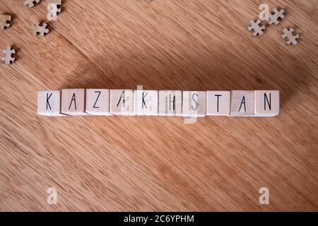 Il paese Kazakhstan scritto su cubetti di legno su sfondo di legno, Foto Stock