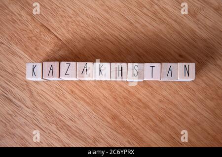 Il paese Kazakhstan scritto su cubetti di legno su sfondo di legno, Foto Stock