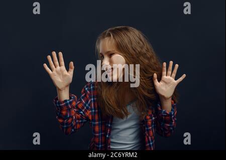 La bambina fa il viso appoggiarsi al vetro Foto Stock