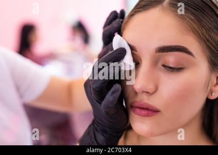 Sopracciglia artista viso pulito con spugna professionale di fronte donna Foto Stock