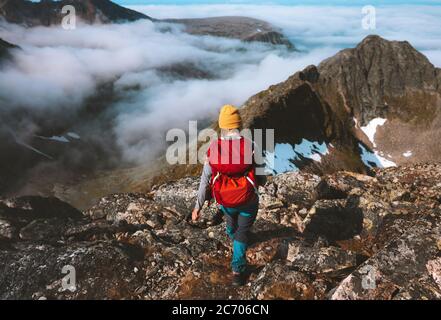 Donna escursioni da sola in montagna con zaino rosso avventura viaggio stile di vita arrampicata solo attivo estate vacanze all'aperto Extreme tour in Norvegia Foto Stock