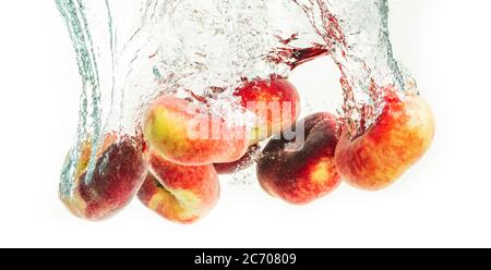 Mazzo di pesche di ciambelle isolate su bianco, spruzzando in acqua. Foto Stock