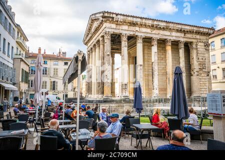 Vienne Francia , 11 luglio 2020 : persone che si trovano in una caffetteria terrazza di fronte al tempio di Augusto e Livia, un antico tempio romano a Vienne Francia Foto Stock