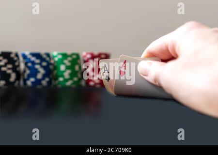 Persona che mostra il suo mazzo due assi al gioco di poker. Chip sullo sfondo. Foto Stock