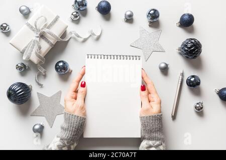 Natale vuoto vuoto vuoto per invito in mani di donna. Natale. Vista dall'alto. Disposizione piatta. Pianificazione delle spese regalo. Foto Stock