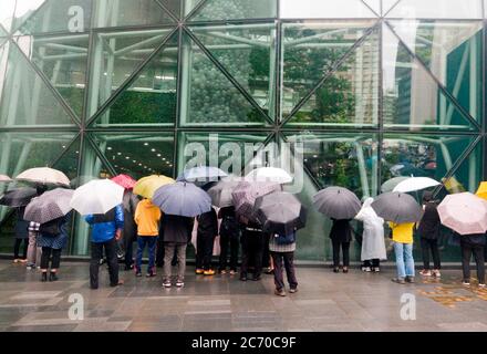 Seoul, Corea del Sud. 13 luglio 2020. La gente guarda all'edificio del Municipio di Seoul, dove si teneva presto un funerale per il tardo Seoul Mayor Park, mentre fu trasmesso online per prevenire possibili infezioni del virus Corona Covid-19 tra i partecipanti a Seoul, Corea del Sud. Park Won-soon era sindaco a tre anni ed era considerato un potenziale candidato presidenziale. Fu trovato morto all'inizio di luglio 10. I media locali hanno riferito che Park è stato accusato di molestare sessualmente la sua ex assistente femminile. Credit: AFLO Co. Ltd./Alamy Live News Foto Stock