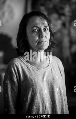 Ritratto di Catarina Bonet, 48 anni, nella sua casa paterna a Riudaura, Spagna (Catalogna). Data: 28/10/2017. Foto: Xabier Mikel Laburu. Originariamente da Barcellona, è venuta in vacanza a Riudaura da quando era una bambina quando suo padre ha comprato una casa nel villaggio. È stata l'ultimo mese che vive a Riudaura. Anche se si sente catalano, riconosce il suo sé come unionista, ma riconosce che l'ambiente le ha trasmesso una certa volontà di indipendenza. Foto Stock