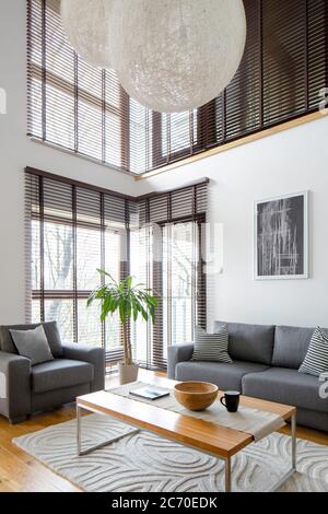 Elegante soggiorno con grandi finestre in appartamento a due piani Foto Stock