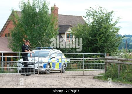 Rook Row Farm, Mathon, Herefordshire, UK - Lunedì 13 luglio 2020 - una polizia di polizia all'ingresso DI AS Green & Co a Rook Row Farm, Mathon - la fattoria rurale Herefordshire attualmente ha oltre 70 casi confermati di Covid-19 tra i 200 lavoratori stagionali sul sito. L'azienda rimane in blocco. Foto Steven maggio / Alamy Live News Foto Stock