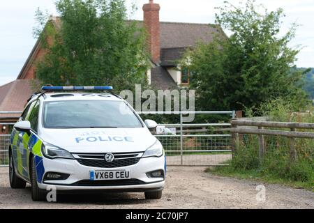 Rook Row Farm, Mathon, Herefordshire, UK - Lunedì 13 luglio 2020 - una polizia di polizia all'ingresso DI AS Green & Co a Rook Row Farm, Mathon - la fattoria rurale Herefordshire attualmente ha oltre 70 casi confermati di Covid-19 tra i 200 lavoratori stagionali sul sito. L'azienda rimane in blocco. Foto Steven maggio / Alamy Live News Foto Stock