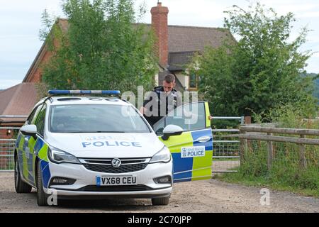 Rook Row Farm, Mathon, Herefordshire, UK - Lunedì 13 luglio 2020 - una polizia di polizia all'ingresso DI AS Green & Co a Rook Row Farm, Mathon - la fattoria rurale Herefordshire attualmente ha oltre 70 casi confermati di Covid-19 tra i 200 lavoratori stagionali sul sito. L'azienda rimane in blocco. Foto Steven maggio / Alamy Live News Foto Stock