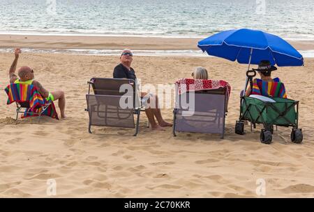 Bournemouth, Dorset UK. 13 luglio 2020. Tempo in Gran Bretagna: Caldo con intervalli di sole alle spiagge di Bournemouth, mentre alcuni amanti del sole si dirigano verso il mare per godersi il sole quando il sole fa un aspetto. Credit: Carolyn Jenkins/Alamy Live News Foto Stock