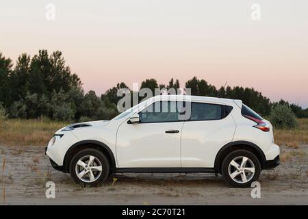 Novoselivka, regione di Dnipropetrovsk, Ucraina - 02 luglio 2020: Nissan Juke 2019 colore bianco vicino alla strada rurale al crepuscolo Foto Stock