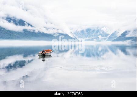 Bellissimo paesaggio con fiordo, barca e nuvole riflesse nell'acqua, Norvegia Foto Stock