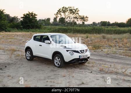 Novoselivka, regione di Dnipropetrovsk, Ucraina - 02 luglio 2020: Nissan Juke 2019 colore bianco vicino alla strada rurale al crepuscolo Foto Stock