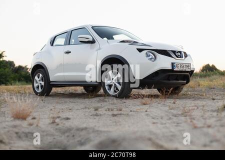 Novoselivka, regione di Dnipropetrovsk, Ucraina - 02 luglio 2020: Nissan Juke 2019 colore bianco vicino alla strada rurale al crepuscolo Foto Stock