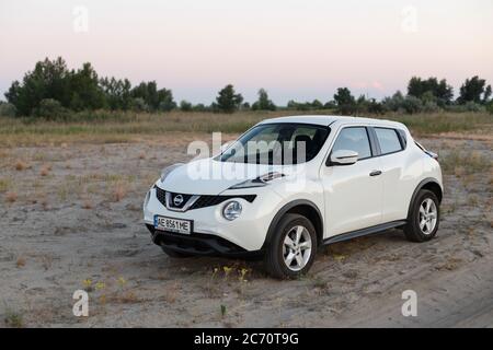 Novoselivka, regione di Dnipropetrovsk, Ucraina - 02 luglio 2020: Nissan Juke 2019 colore bianco vicino alla strada rurale al crepuscolo Foto Stock