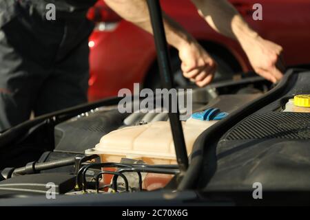 Motore di fissaggio manuale. Ispezione della vettura. Lavoro di meccanico Foto Stock