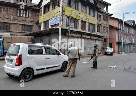 Kashmir, India. 13 luglio 2020. Le forze governative arrestano un veicolo in un punto di controllo durante un blocco reimposto per impedire la diffusione del coronavirus.Lockdown è stato reimposto nella valle del Kashmir dopo un improvviso aumento dei casi COVID-19 nell'ultima settimana, i funzionari hanno detto che sono state imposte rigorose restrizioni e che non vi è movimento di persone, sono ammessi, tranne i servizi essenziali e le emergenze mediche. Credit: SOPA Images Limited/Alamy Live News Foto Stock