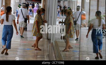 Palma, Spagna. 13 luglio 2020. Una donna che indossa un boccaglio entra in un negozio nel centro di Palma. A Maiorca e nelle altre isole Baleari, un ampio obbligo di mascheramento è di entrare in vigore lunedì a causa della pandemia di Corona. Credit: Clara Margais/dpa/Alamy Live News Foto Stock